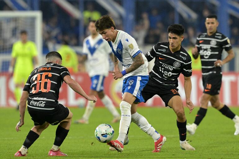 El delantero de Vélez Sarsfield, Maher Carrizo, traslada el balón ante la presencia de  Facundo Zabala (36) y el volante ofensivo Luis Carlos Abreu. (Foto de JUAN MABROMATA / AFP)"